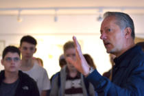 Kunstlehrer Hanns Göbel erläutert die Ausstellung "Epochen – Junge Kunst aus dem Freiherr-vom-Stein-Gymnasium" in Freusburg